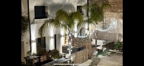 a building with a palm tree in front of it at Les Gîtes de la Chapelle 4 in Vauvert