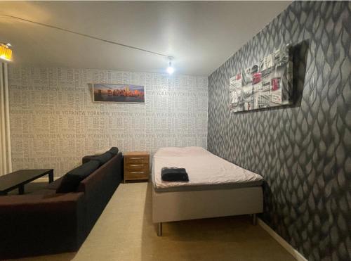 mały pokój z łóżkiem i kanapą w obiekcie Helsinki Apartment near downtown w Helsinkach
