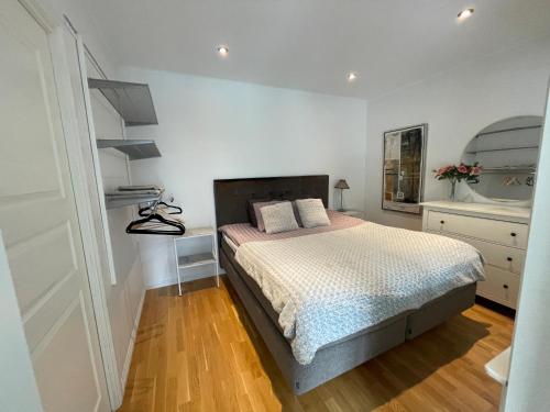 a white bedroom with a bed and a wooden floor at nikos house; in Stockholm