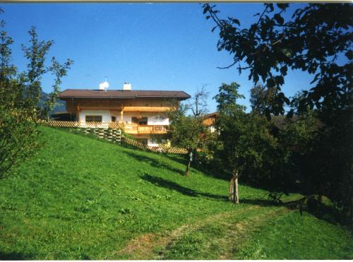 a house on top of a hill with a green field at Ferienhaus Waidmannsruh in Hippach