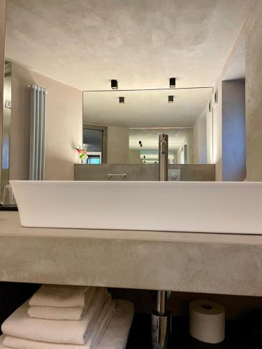 a bathroom with a large mirror and a pile of towels at La Rêverie de Thumel - Suite in Rhêmes-Notre-Dame