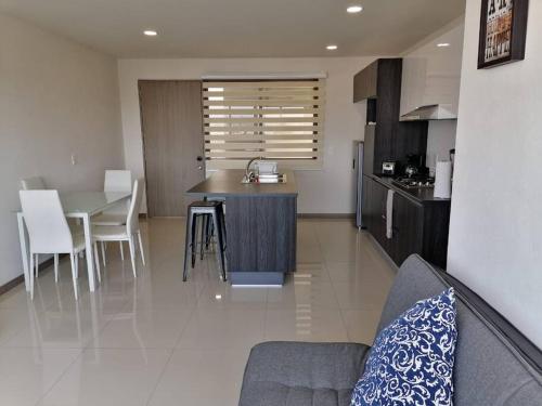 a living room and kitchen with a couch and a table at Atemajac Apartment 1parking/2BR/2BA in Guadalajara
