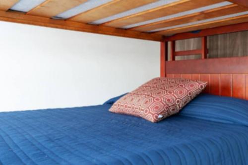 a blue bed with a pillow on top of it at Atemajac Apartment 1parking/2BR/2BA in Guadalajara