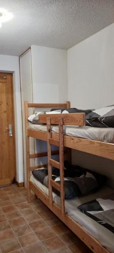 a room with two bunk beds in a room at le petit montagnard in Thollon