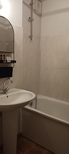 une salle de bain avec un lavabo et une baignoire dans l'établissement le petit montagnard, à Thollon-les-Mémises