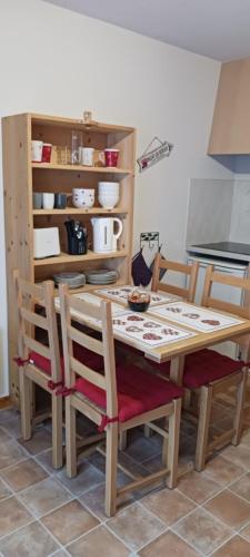 une cuisine avec une table, des chaises et un comptoir dans l'établissement le petit montagnard, à Thollon-les-Mémises