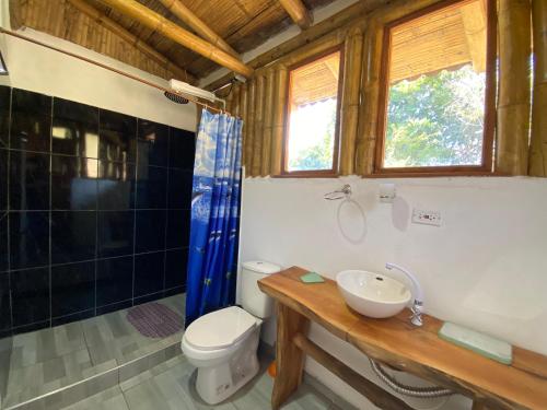 a bathroom with a toilet and a sink and a shower at Cabañas Ecoturismo Evy in Macanal