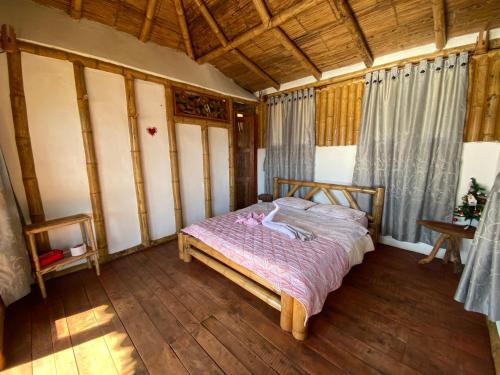 ein Schlafzimmer mit einem Bett in einem Zimmer mit Holzböden in der Unterkunft Cabañas Ecoturismo Evy in Macanal