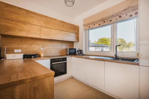 a kitchen with white cabinets and a window at VILLA JADRANKA in Krnica