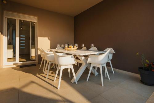 a dining room with a table and white chairs at VILLA JADRANKA in Krnica