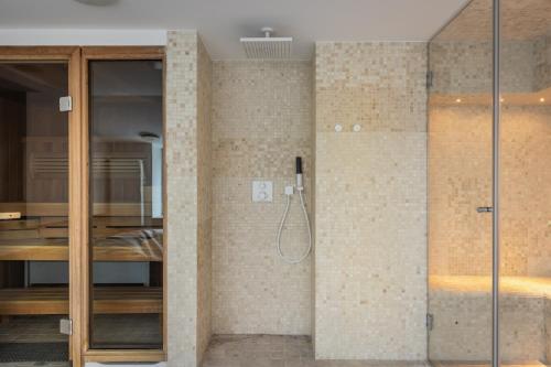 bagno con doccia e porta in vetro di Boutique Penthouse a Vilnius