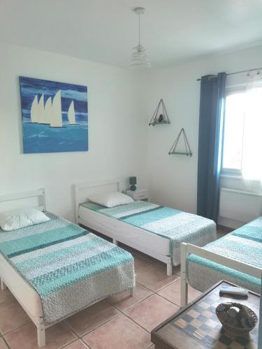 une chambre avec trois lits et une fenêtre dans l'établissement Rez Haut de villa à Calenzana, à Calenzana