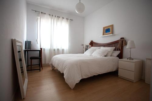 a bedroom with a white bed and a window at Acogedor piso en pleno centro de Santander in Santander