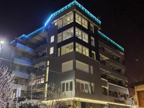 a building with a sign on top of it at night at Apartman Iris in Vrnjačka Banja