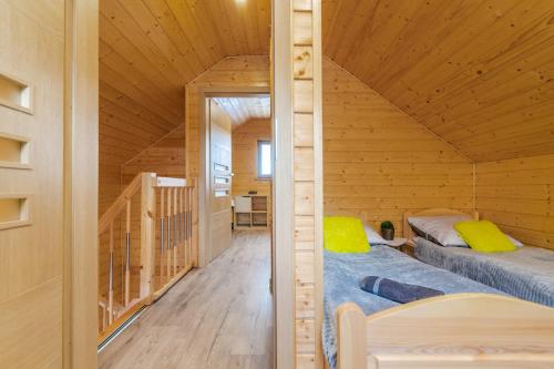 um quarto com 2 camas num chalé de madeira em Domki u Magdaleny em Sztutowo