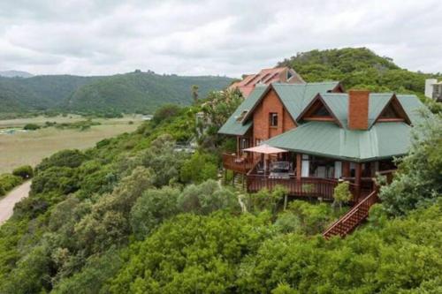 a house on a hill with a green roof at Wilderness deckhouse. views!/sun/sea/river/kayaks in Wilderness