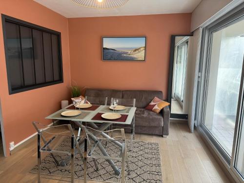 un salon avec une table et un canapé dans l'établissement Chez Tonton, Studio cabine au calme avec parking, à Le Touquet-Paris-Plage