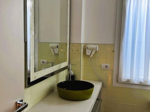 a bathroom with a green sink and a mirror at Locanda LaRotonda in Villa Verucchio