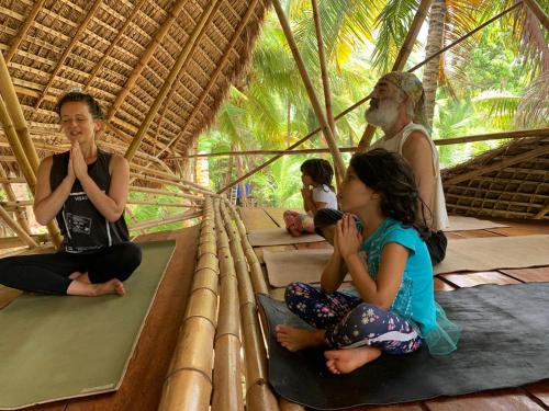 リトル・コーン島にあるENSUEÑOS NATURAL RESERVE Little Corn Island Nicaraguaの藁小屋に座る人々