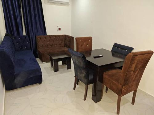 ein Wohnzimmer mit einem Tisch, Stühlen und einem Sofa in der Unterkunft 2BE HOTELS SUITES AND EVENTS 