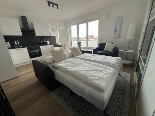 ein weißes Bett in einem Zimmer mit Küche in der Unterkunft Tor nach Hannover in Springe