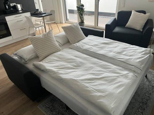 ein großes Bett mit weißer Bettwäsche und Kissen in einem Zimmer in der Unterkunft Tor nach Hannover in Springe