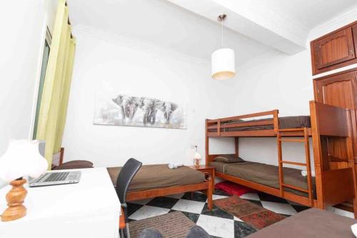 Zimmer mit einem Bett und Etagenbetten. in der Unterkunft Appartement Tetouan Saniat Ramel Airport Plage Martil WIFI in Tétouan