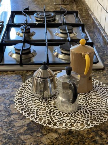 a stove top with two tea pots and a tea kettle at Mazzetti Country House-Vita in campagna con giardino in Vimignano