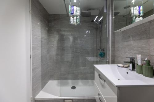 a bathroom with a shower and a white sink at Cours de Vincennes Suite PARIS 12 in Paris