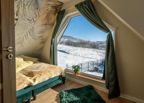 um quarto com uma cama e uma janela com vista para o Inverno em Ostoja Pod Osówką dom Spokój em Sierpnica