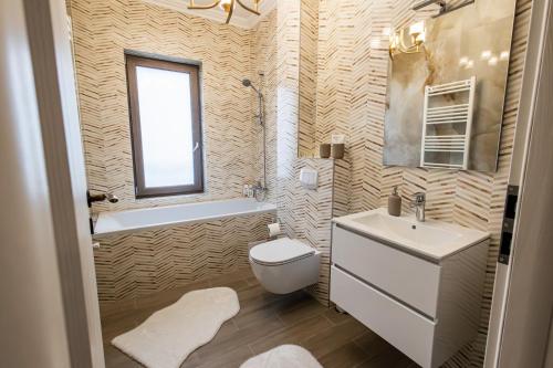La salle de bains est pourvue d'un lavabo, de toilettes et d'une fenêtre. dans l'établissement Maieru’s Apartament Dumbravita, à Uisenteş