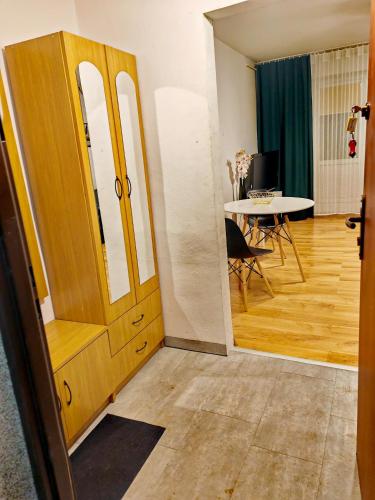 Cette chambre dispose d'une porte en bois et d'une table avec une table. dans l'établissement Apartament Chełmsko, à Chełmsko Śląskie