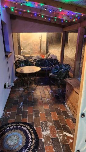 a patio with a table and chairs and lights at Domek drewniany in Piekielnik