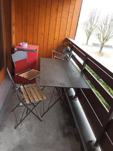 - une table de pique-nique et 2 chaises assises sur une terrasse couverte dans l'établissement Appart 4P face télécabine GME, à Samoëns