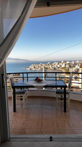 a table and chairs on a balcony with a view of the ocean at Sea View Apartments in Sarandë