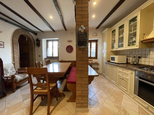 a kitchen with a wooden table and a dining room at Mazzetti Country House-Vita in campagna con giardino in Vimignano