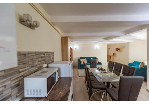 un soggiorno con tavolo da pranzo e televisione di Luxury Apartment a Piteşti