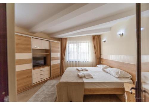 una camera da letto con un letto grande e una televisione di Luxury Apartment a Piteşti
