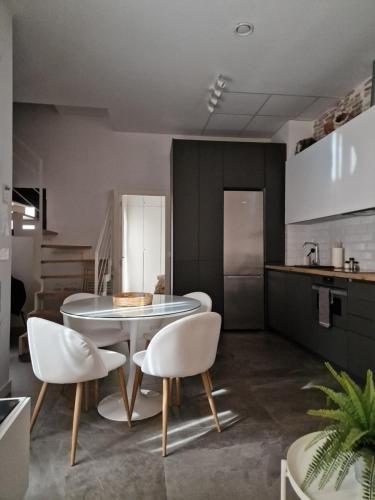 kuchnia ze stołem i krzesłami w pokoju w obiekcie Atico en Puerta Osario w Sewilli