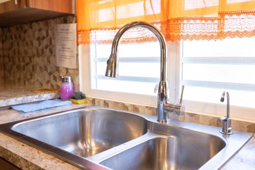 fregadero de acero inoxidable en una cocina con ventana en Arenales Vacational House en Isabela