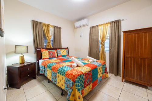 um quarto com uma cama com um edredão colorido em Arenales Vacational House em Isabela