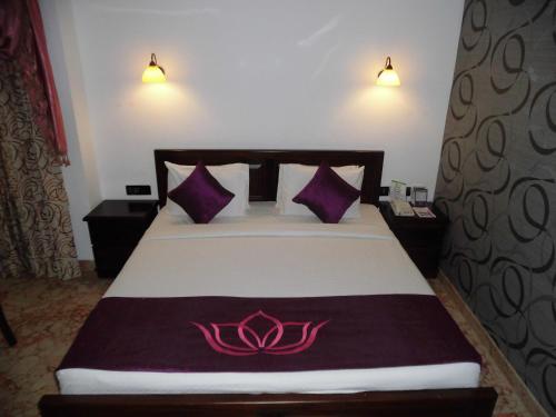 Una cama o camas en una habitación de Lakshmi Hotel