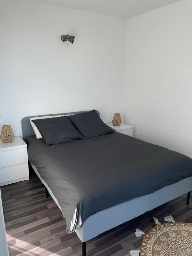 Ce lit se trouve dans une chambre dotée d'un mur blanc. dans l'établissement Appartement confortable aux portes de Paris, à Charenton-le-Pont