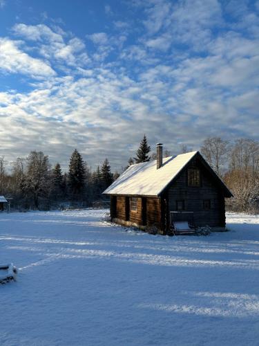 an old cabin in a field with snow on it at Saunja Homestay in Saunja