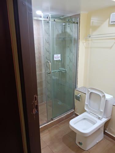 a bathroom with a glass shower and a toilet at Equity resort hotel ijebu in Ijebu Ode