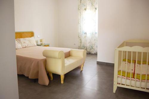 a bedroom with a bed and a chair and a crib at PASSAR P'LAS BRASAS in Mourão