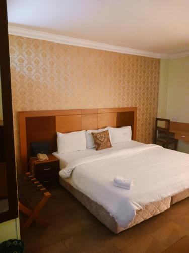 a bedroom with a large bed with white sheets at Equity resort hotel ijebu in Ijebu Ode
