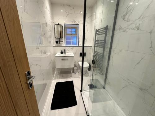 un bagno con doccia, WC e lavandino di Hudson Apartment - 2 bedroom, Oakham Centre by Belmont Places a Oakham
