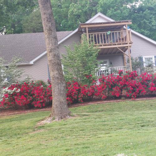 Casa con balcón con flores rojas en Serenity Hill bed and Breakfast en Brownsville