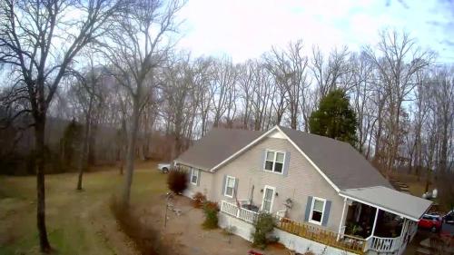 a house in a yard with trees in the background at Serenity Hill bed and Breakfast in Brownsville